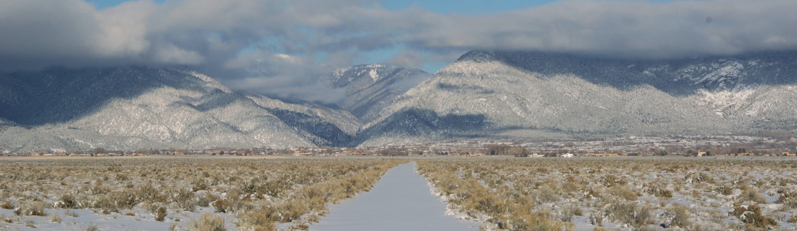 Snowy path leading to snowy Taos mountain