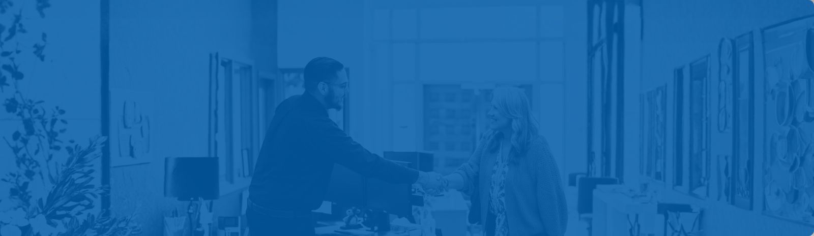 Jerome Vigil loan coordinator shaking hands with a female customer in loan lobby.